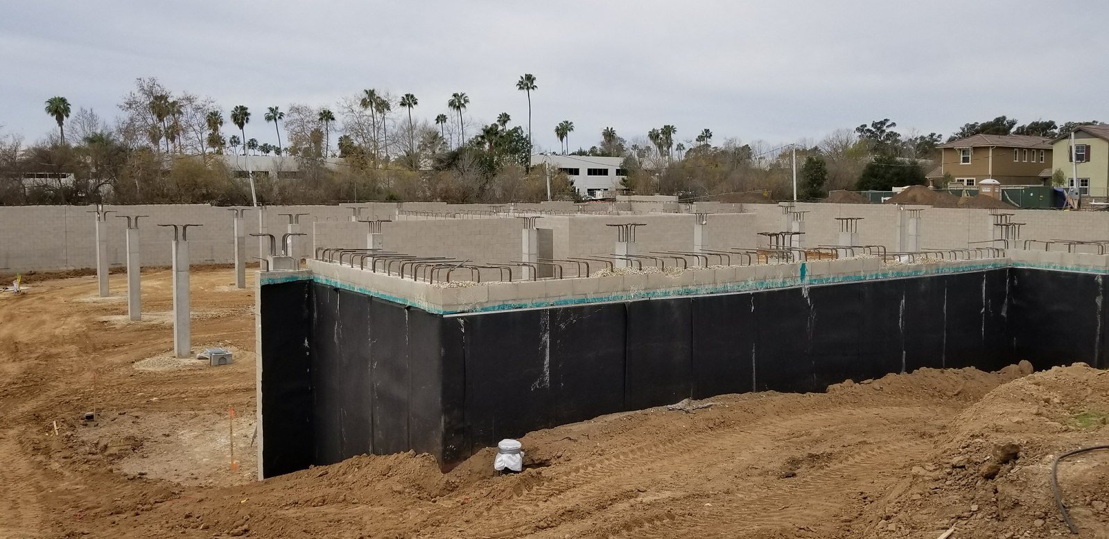 Below-grade waterproofing membrane installation at a multifamily residential foundation