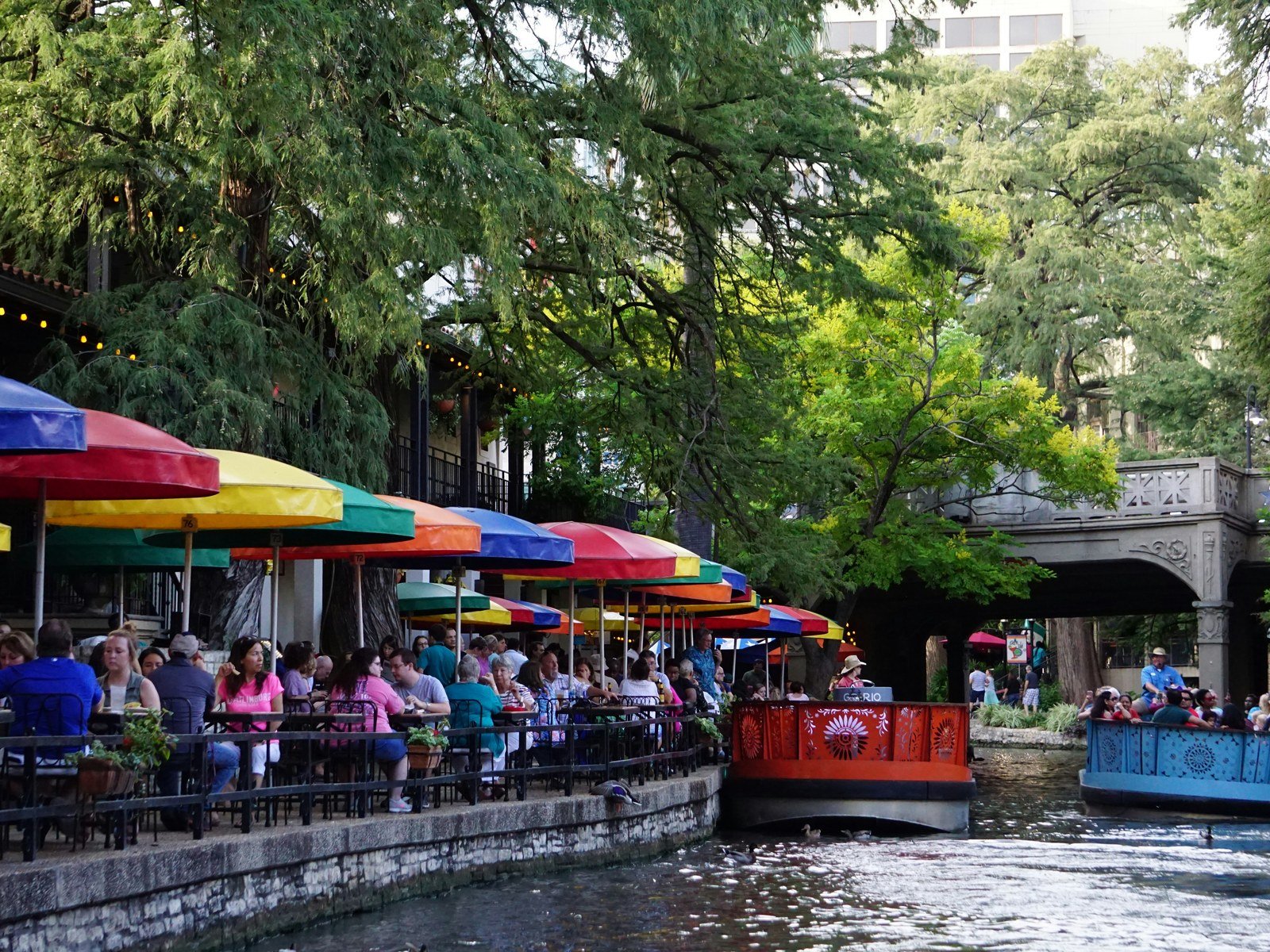 San Antonio River Walk with colorful umbrellas and river barges